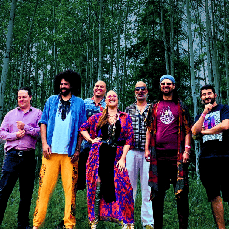 Band performing outdoors in a forest, showcasing vibrant music and lively atmosphere.